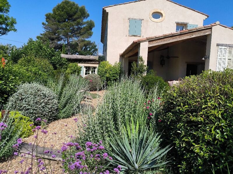 Un jardin sec avec des plantes résistantes entoure une maison