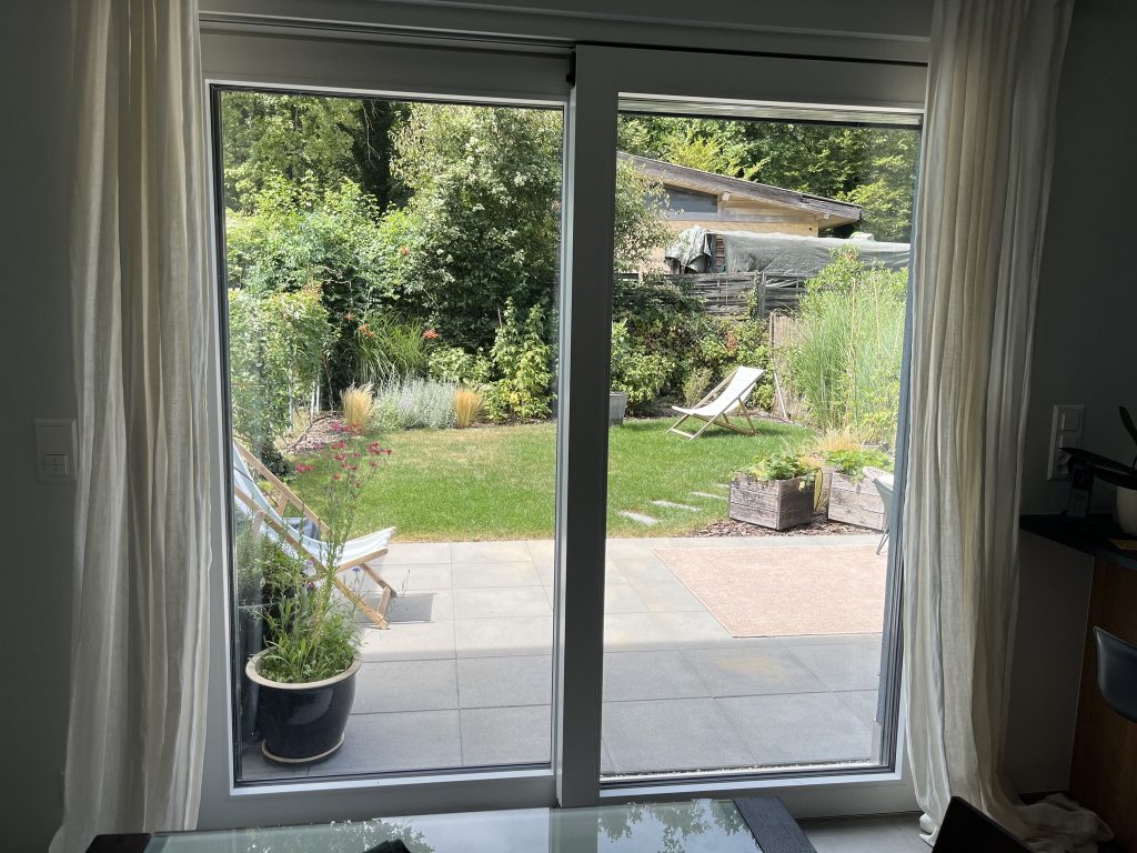 Vue vers le jardin à travers une grande baie vitrée