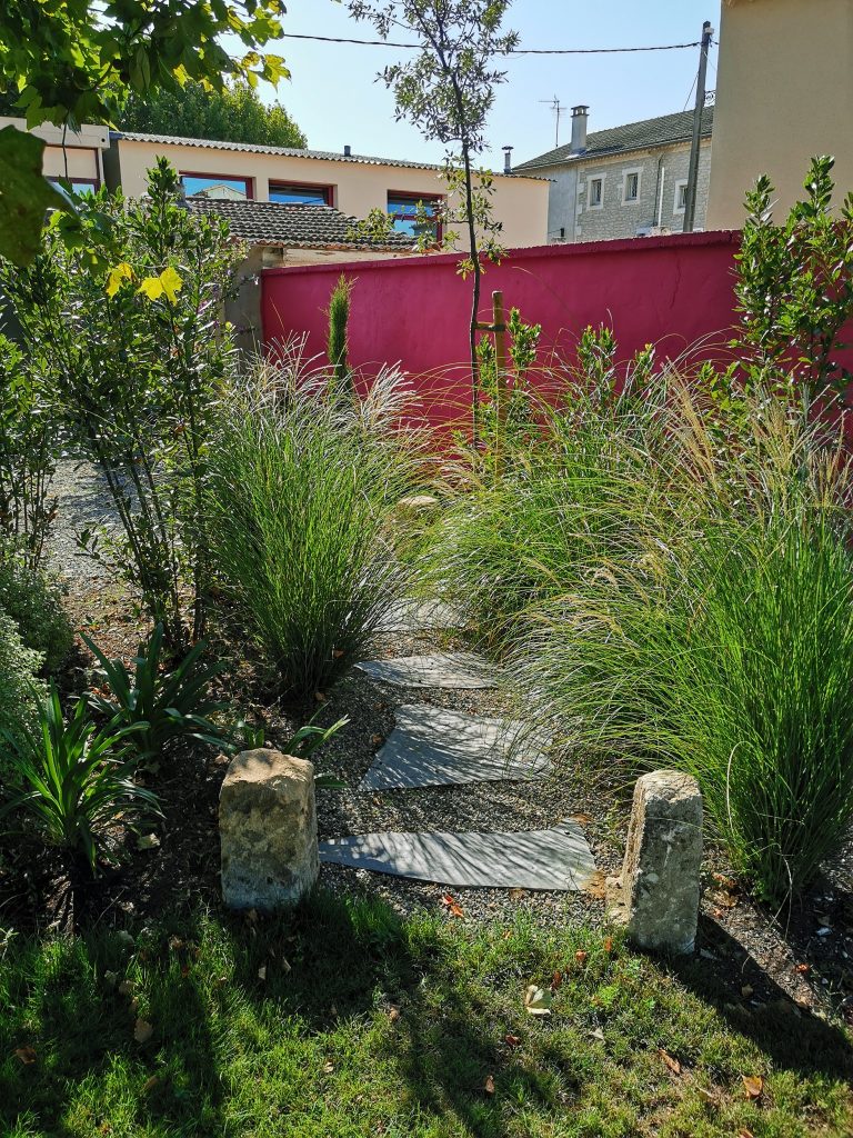Jardin avec mur rouge et plantations