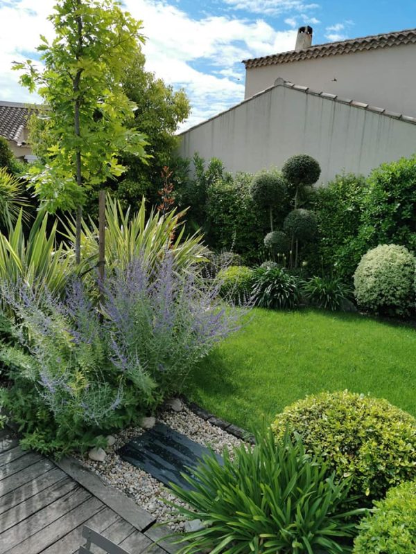 Jardin avec topiaires et pelouse devant un mur