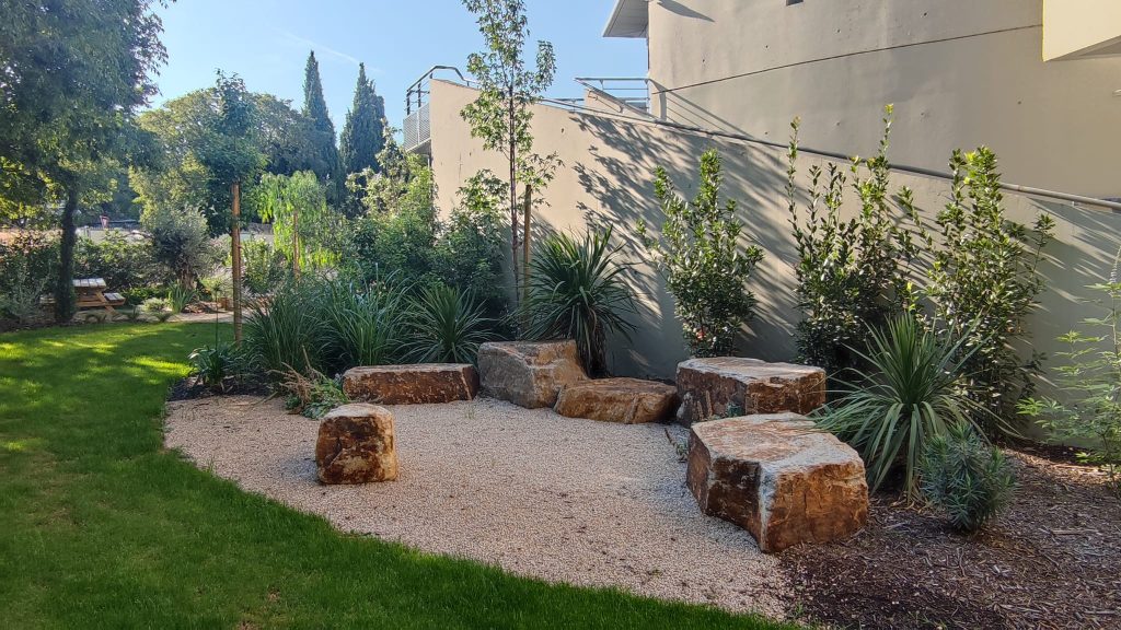 Jardin paysager avec plantes devant un mur