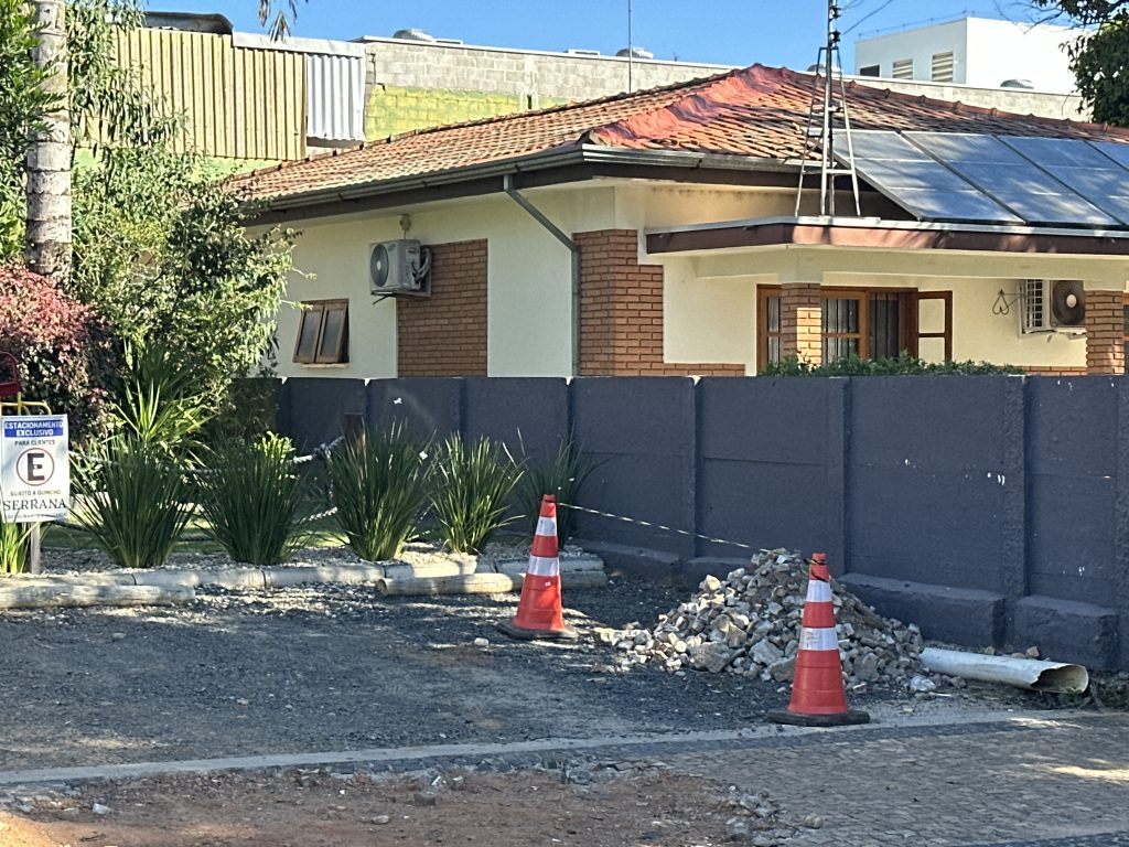 Mur de clôture sombre en construction devant une maison 