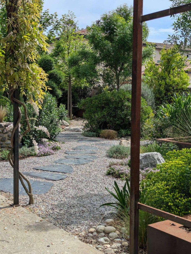 Arbres au jardin qui font de l'ombre sur l'allée