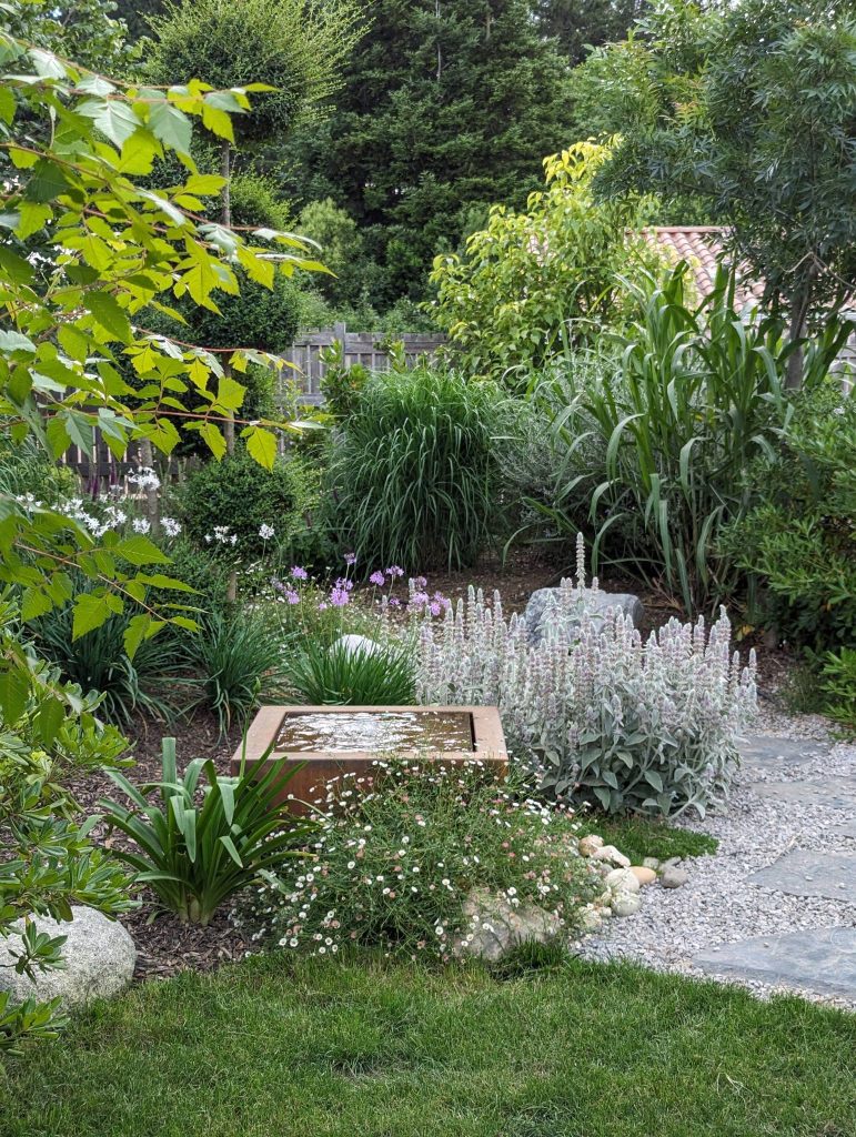Jardin fleurs avec chemin gravier et verdure